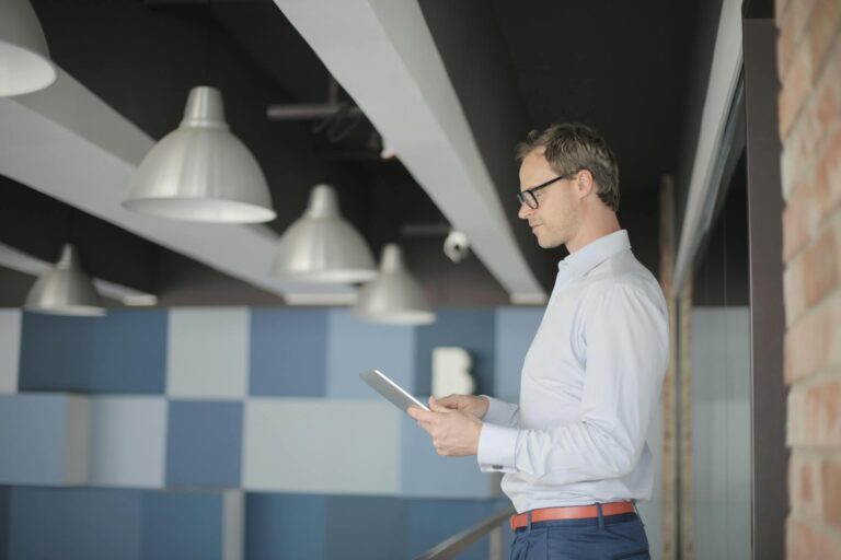 Businessman in smart casual using a tablet in a modern office setting.